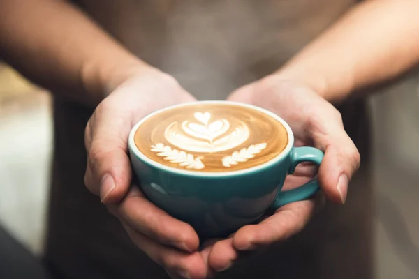 Barista Ręce Trzymając Filiżankę Kawy Prezentując Piękny Wzór Rosetta Latte — Zdjęcie stockowe