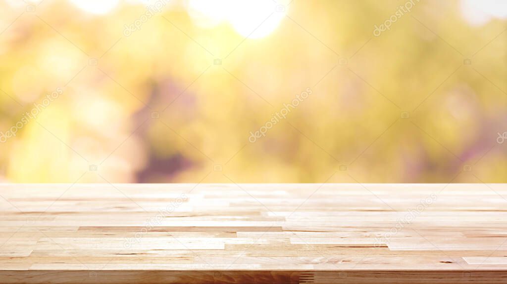 Wood table top on blur abstract natural foliage bokeh background, vintage tone - can be used for display or montage your products