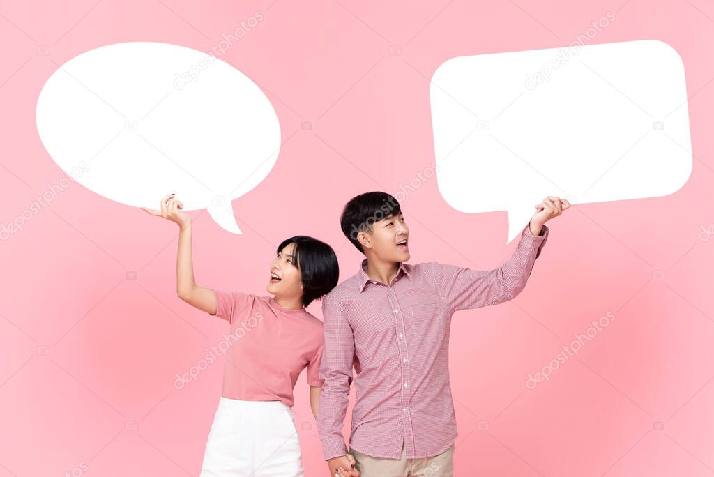 Lovely smiling young Asian couple with speech bubbles studio shot on pink background