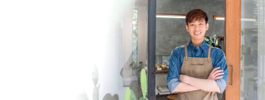 Genç girişimci Asyalı adam kendi kafesinin önünde duruyor ve kollarını kavuşturuyor. Panoramik afiş ve fotokopi alanı.