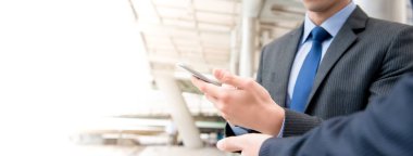 İş adamı akıllı telefondan ortakla projeyi tartışıyor, kopyalama alanı olan panoramik pankart