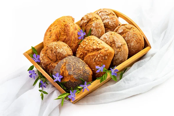 Buns on a wooden tray and wildflowers. Isolate on white background