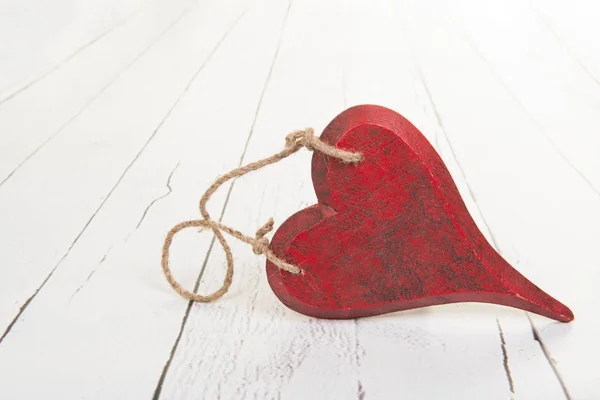 Corazón rojo de madera sobre madera blanca — Foto de Stock