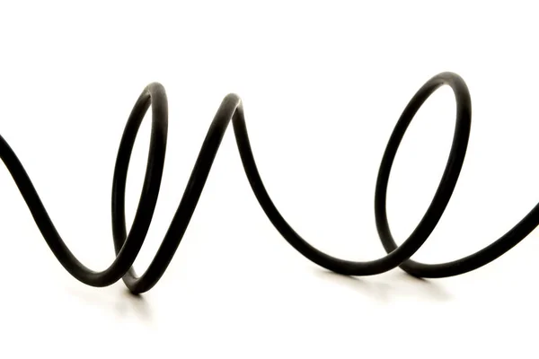 Скрученный чёрный провод на белом фоне — стоковое фото