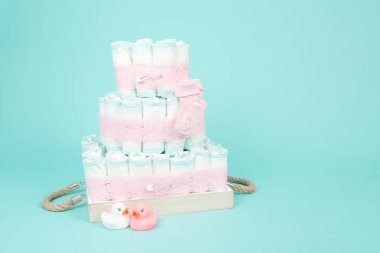 Bebek bezi pasta lastik ördek ve mavi bir arka plan üzerinde pembe çorap ile