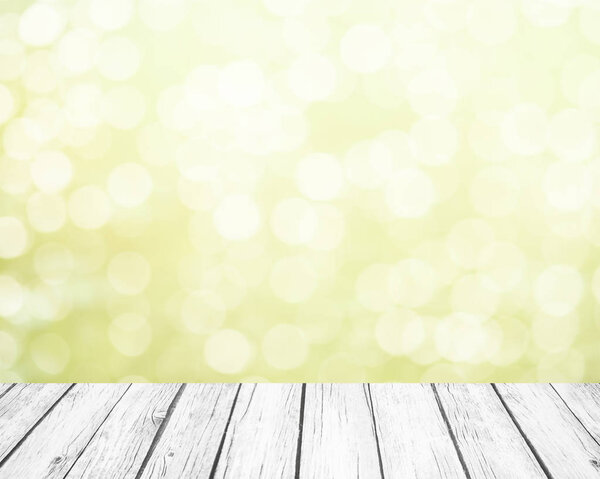 Мягкий зеленый весенний фон с белым боке и белыми деревянными досками в качестве пола
