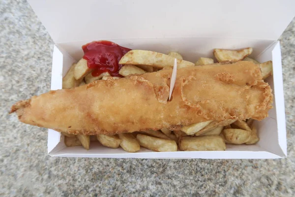 Fish and chips in a carton box seen from above