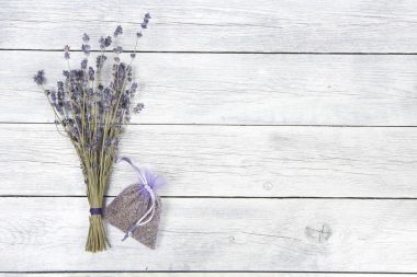 Lavanta poşet ve kurutulmuş lavanta çiçek alanı kopya için bir beyaz ahşap plakalar zemin üzerine bir demet