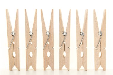 Bir çizgi beyaz bir arka plan ve beyaz bir zemin üzerinde duran clothespins grup