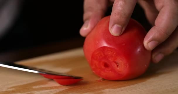 Chef cuts fresh tomato using the kitchen knife. 4K — Stockvideo