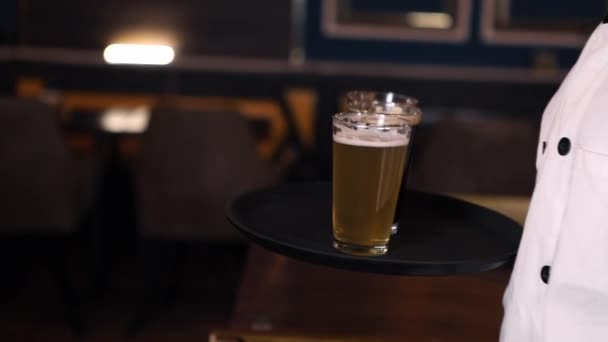 Waiter is serving beer for customers in the pub. Slow Motion — Stockvideo