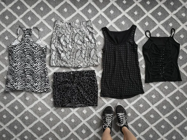 Выбор стильной одежды на полу — стоковое фото