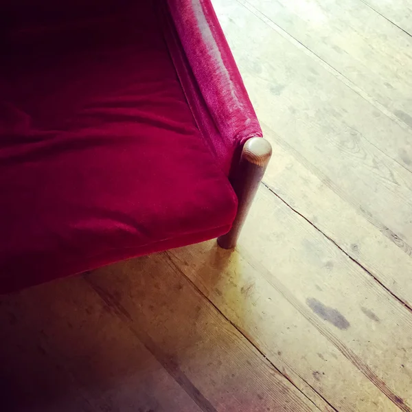 Vintage red aksamitny fotel na drewnianej podłodze — Zdjęcie stockowe
