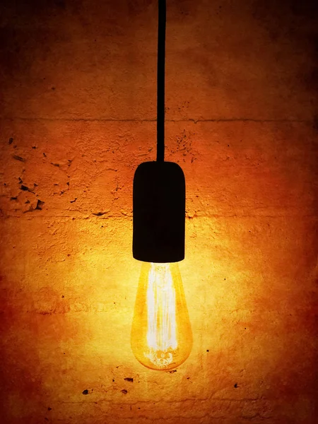 Лампочка на старинном оранжевом фоне — стоковое фото