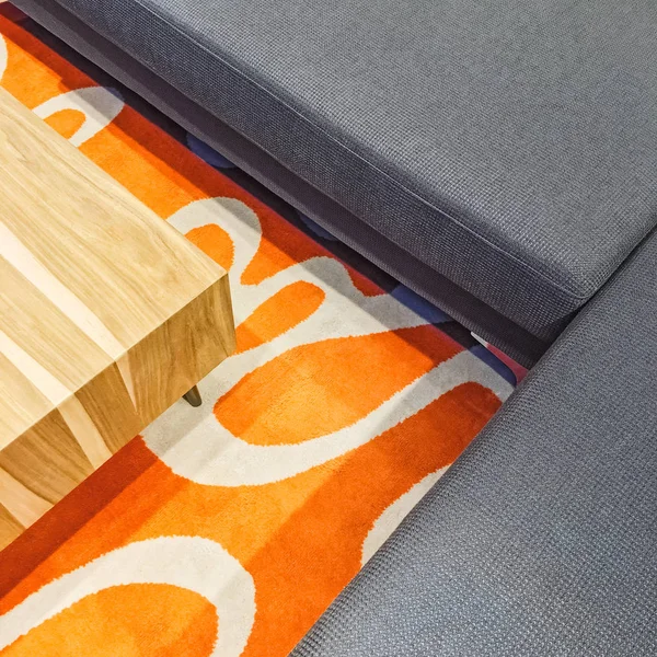 Gri köşe kanepe ve turuncu halı — Stok fotoğraf
