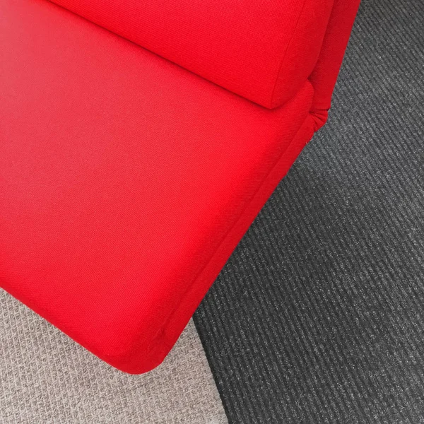 Lebendiger weicher roter Stuhl auf grauem Teppich — Stockfoto