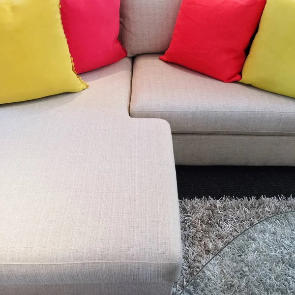 Cojines rojos y amarillos en sofá esquinero gris —  Fotos de Stock