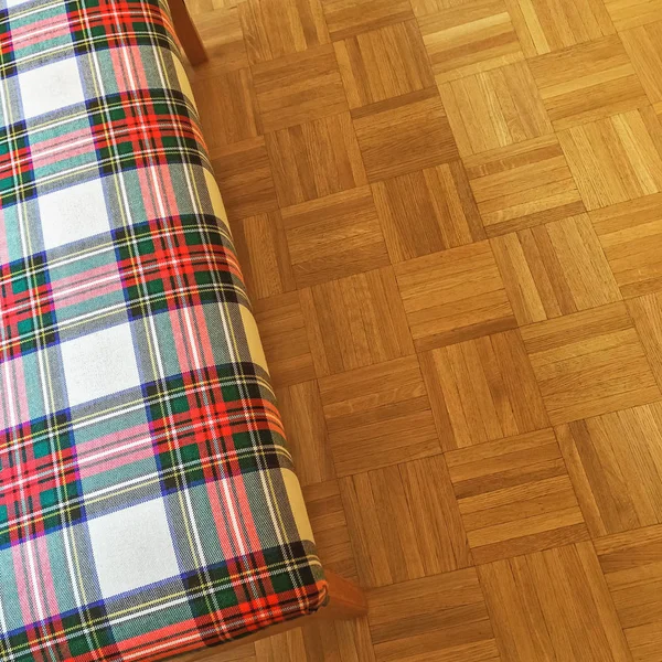 Banqueta textil a cuadros en el suelo de parquet — Foto de Stock