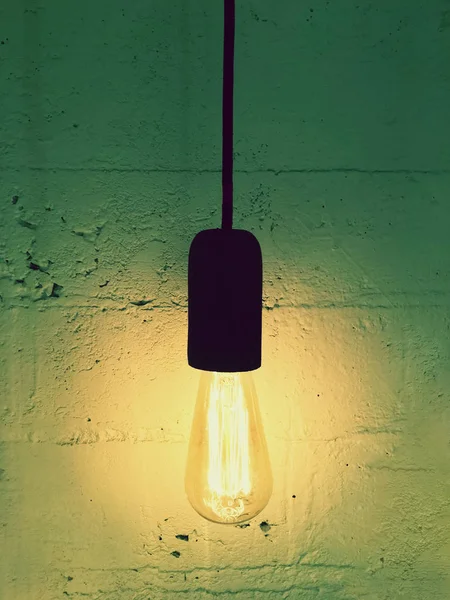 Simple light bulb on a black cord — Stock Photo, Image