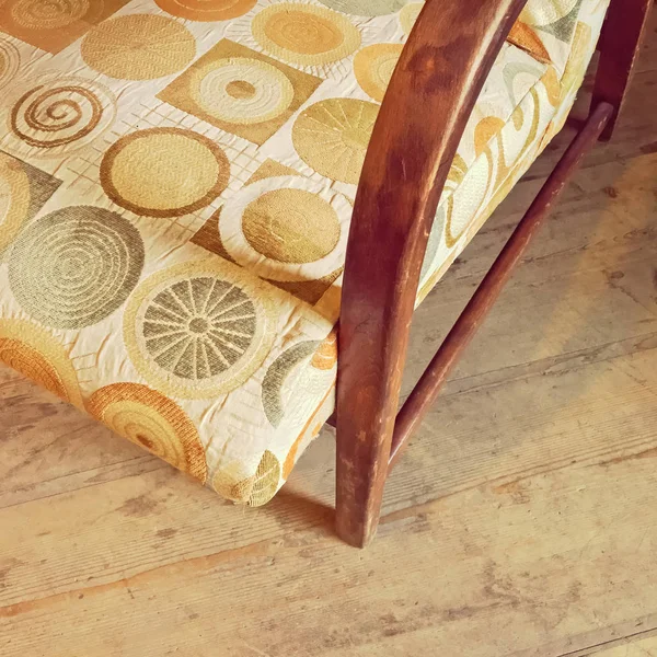 Деталь старинного текстильного кресла на деревянном полу — стоковое фото