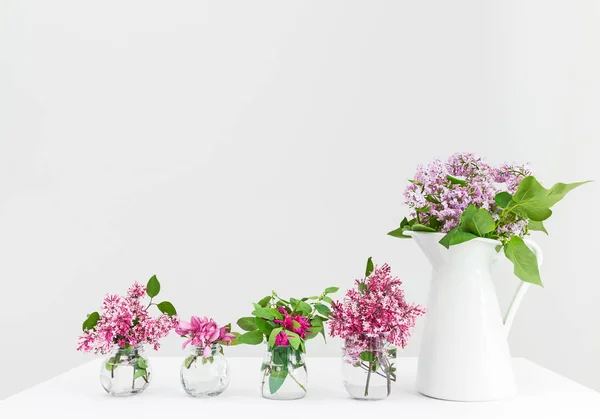 Vaser med rosa och lila vårblommor — Stockfoto