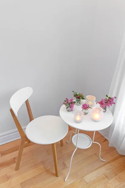 Interior branco elegante com luzes de vela e flores de primavera — Fotografia de Stock