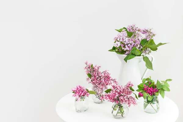 Vaser med blommande våren blommor på ett runt bord — Stockfoto