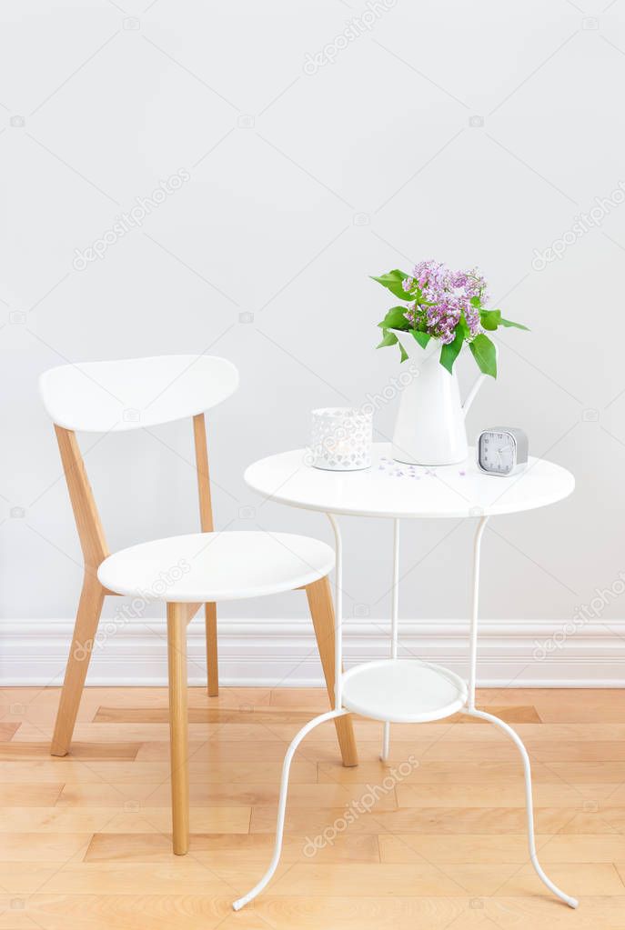 Elegant interior with table, chair and bouquet of lilacs