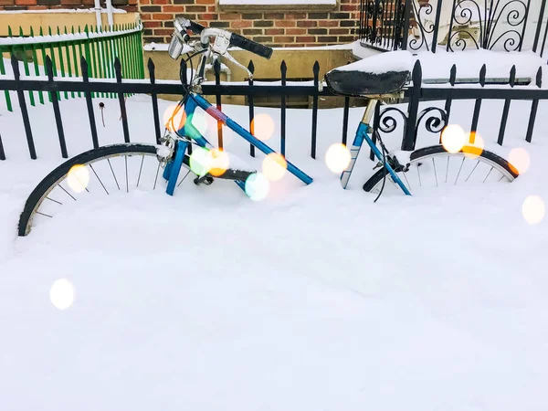 Bicycle in snow near urban building, with bokeh light effect — Stock Photo, Image