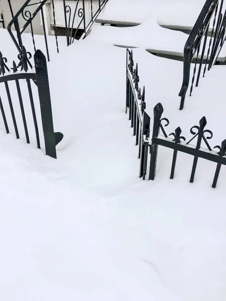 Железный забор в глубоком снегу — стоковое фото