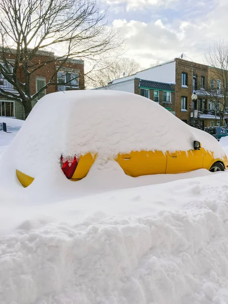 Urban street met een gele auto vast te zitten in de sneeuw — Stockfoto