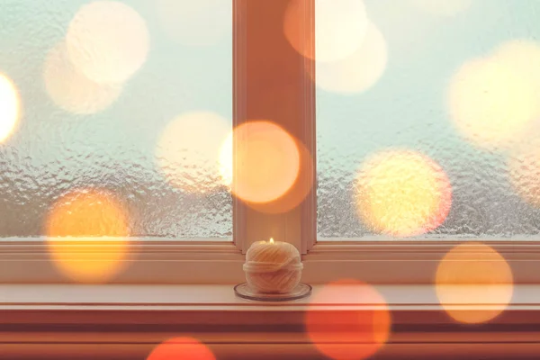 Gezellige kaars op een vensterbank in het gouden licht — Stockfoto
