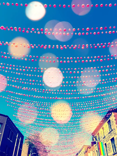 Festive street in gay neighborhood decorated with pink balls