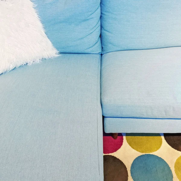Fluffig vit dyna på blå textil soffa — Stockfoto