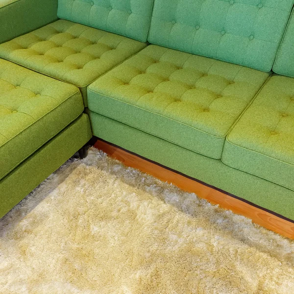 Green corner sofa on fluffy rug — Stock Photo, Image