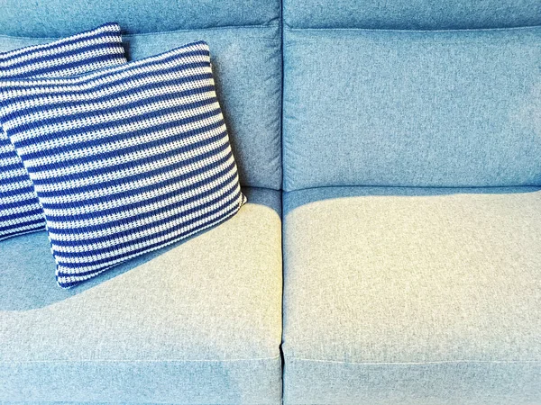 Striped cushions on a blue textile sofa — Stock Photo, Image