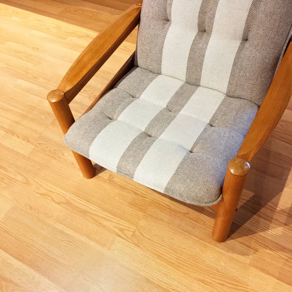 Comfortabele gestreepte fauteuil op een houten vloer — Stockfoto