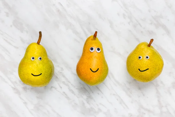 Αστείο χαμογελώντας αχλάδια σε μαρμάρινο φόντο — Φωτογραφία Αρχείου