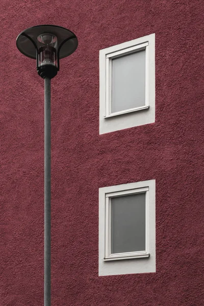 Lampadaire devant un bâtiment rouge foncé — Photo