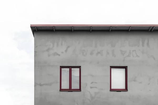 Fasad av ett grått hus med röda fönster — Stockfoto