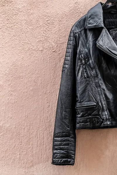 Black leather jacket on pink wall — 图库照片