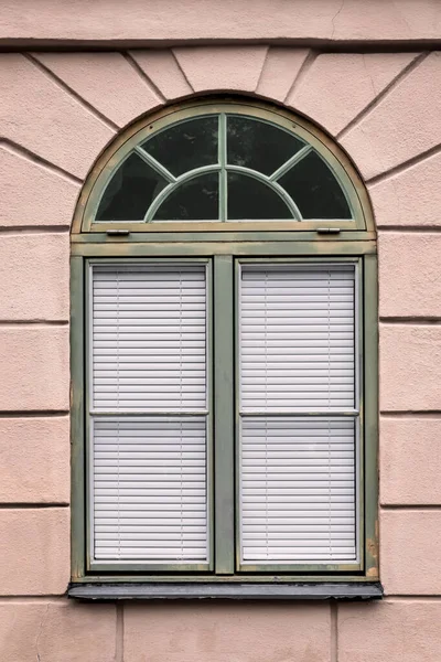 Pinkfarbenes Gebäude Mit Einem Abgerundeten Grünen Fenster Europäische Stadt lizenzfreie Stockbilder