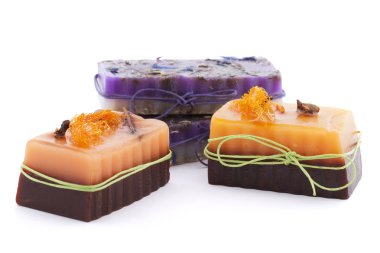 Karanfil, yıldız, tarçın, lif kabağı ve kır çiçekleri beyaz arka plan üzerinde izole üstte üç çikolata portakal sabunlar