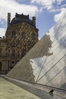Paris, Fransa: Louvre Müzesi cephesi. 11 Temmuz 2018. Müze dünyanın en iyi resim, heykel ve arkeoloji koleksiyonlarından birine sahip. 1989 yılında müzenin büyük gri bloklarının monotonluğunu kıran cam bir piramit inşa edildi.