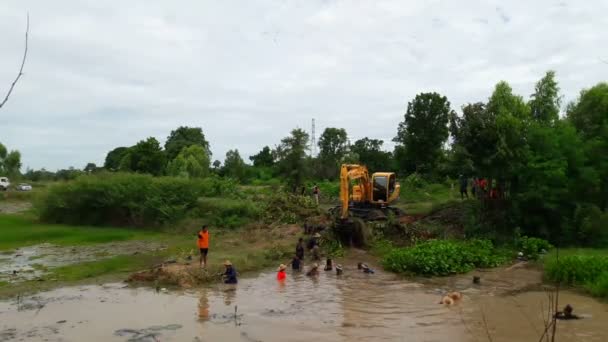 很多人和反铲挖土机来帮忙打扫和疏浚运河水用于 agriculture.:Mahasarakham，泰国，6 月 18,2017 — 图库视频影像