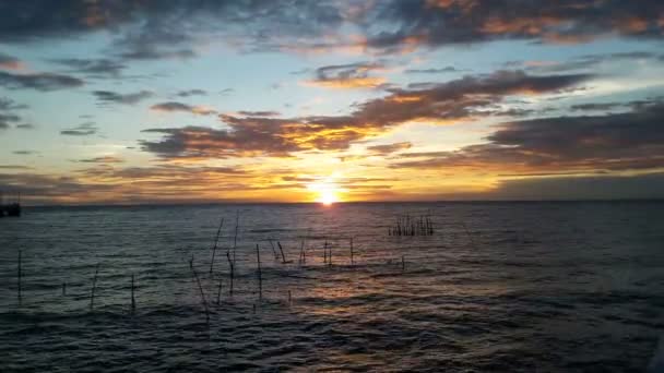 Coucher de soleil derrière la mer a un beau ciel orange . — Video