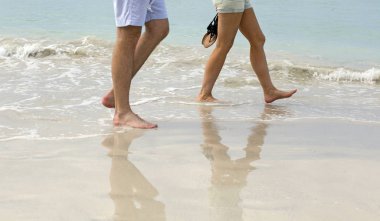 Islak kumsalda yürüyen insanlar closeup