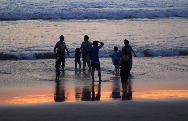 日没時のビーチで人々のシルエットのグループ — ストック写真
