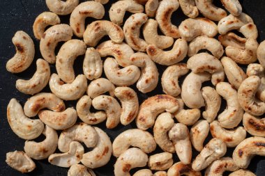 Kavrulmuş kaju fıstığı ve tuzlu tuzu panoya koy..