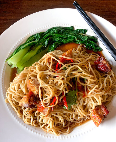 Crispy roasted pork belly over noodles and bok choy stir fry.